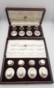 Two leather cased sets of eight novelty silver place card holders, four modelled as a lady's straw