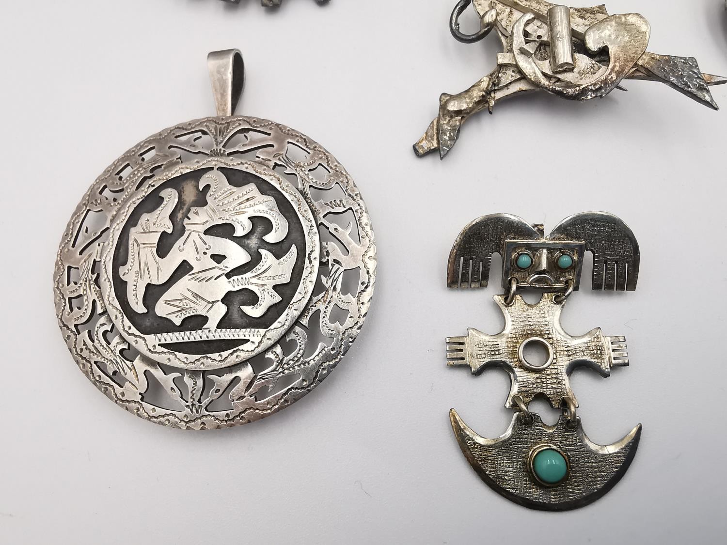 A large collection of silver and white metal Mexican, Mayan and Aztec design brooches, pendants - Image 2 of 9