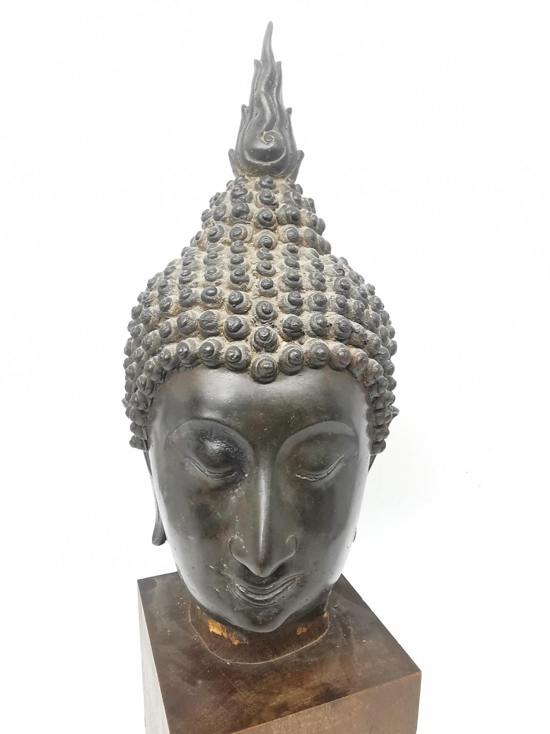 A 19th century Sukhothai style Thai bronze Buddha head on a wooden block stand. The head with serene - Image 2 of 11