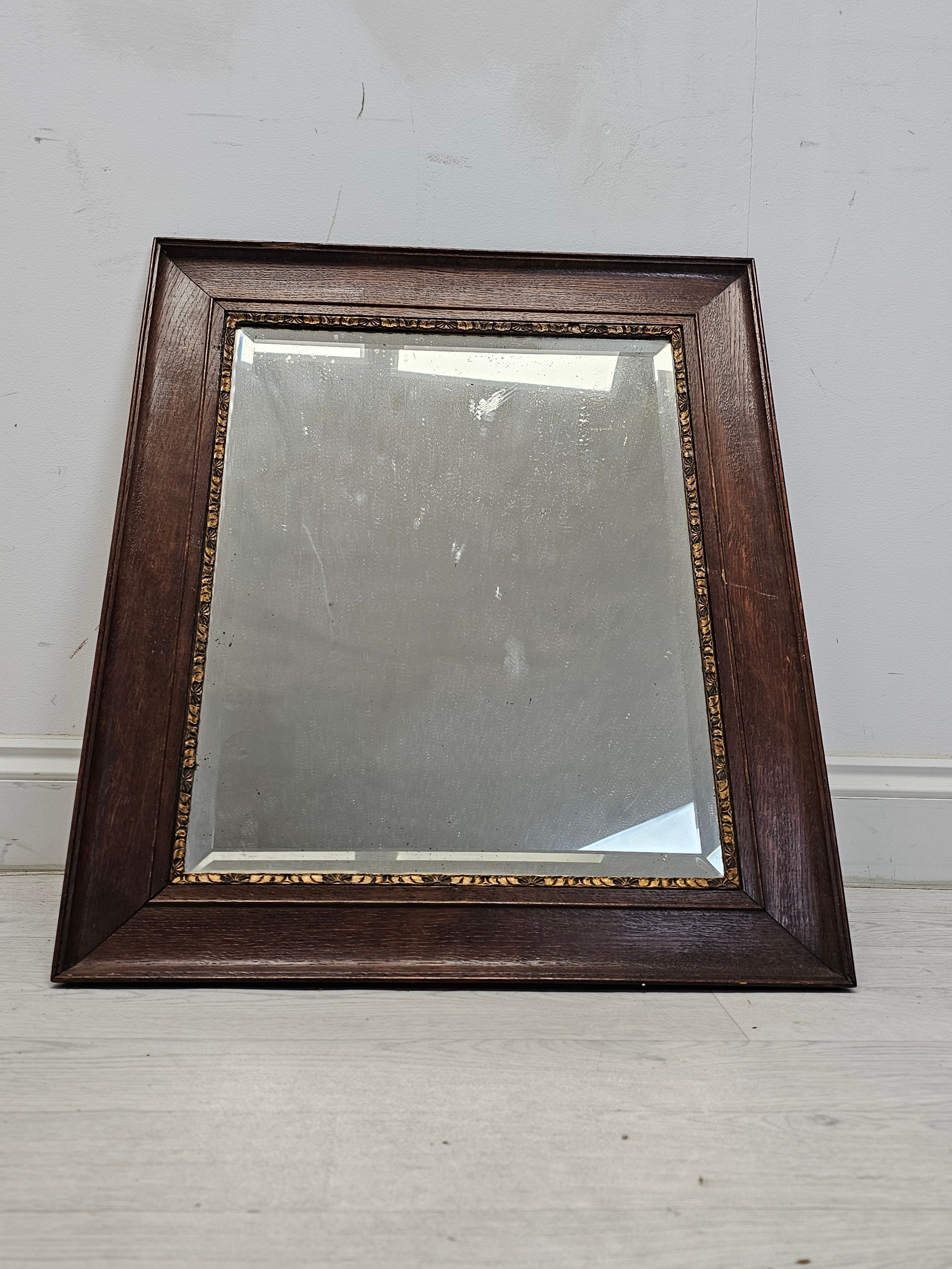 A vintage oak framed mirror with bevelled plate. H.66 W.56cm.