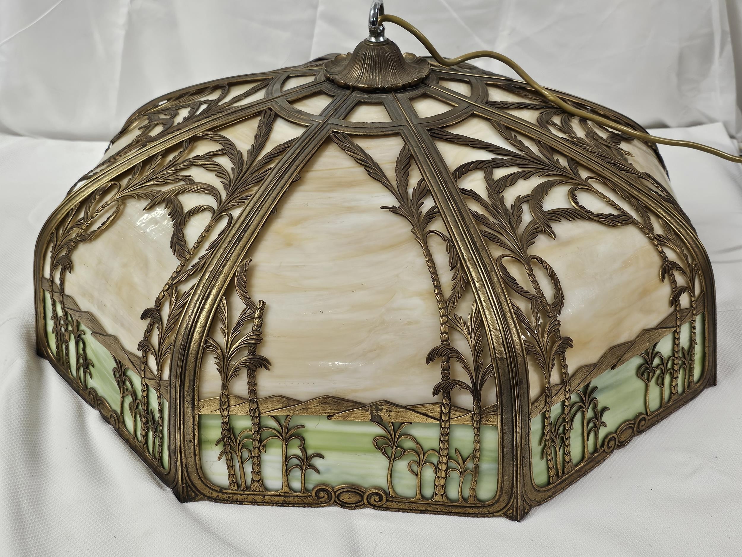 An Art Deco Miller style bronze overlay slag glass ceiling light with palm tree and mountain