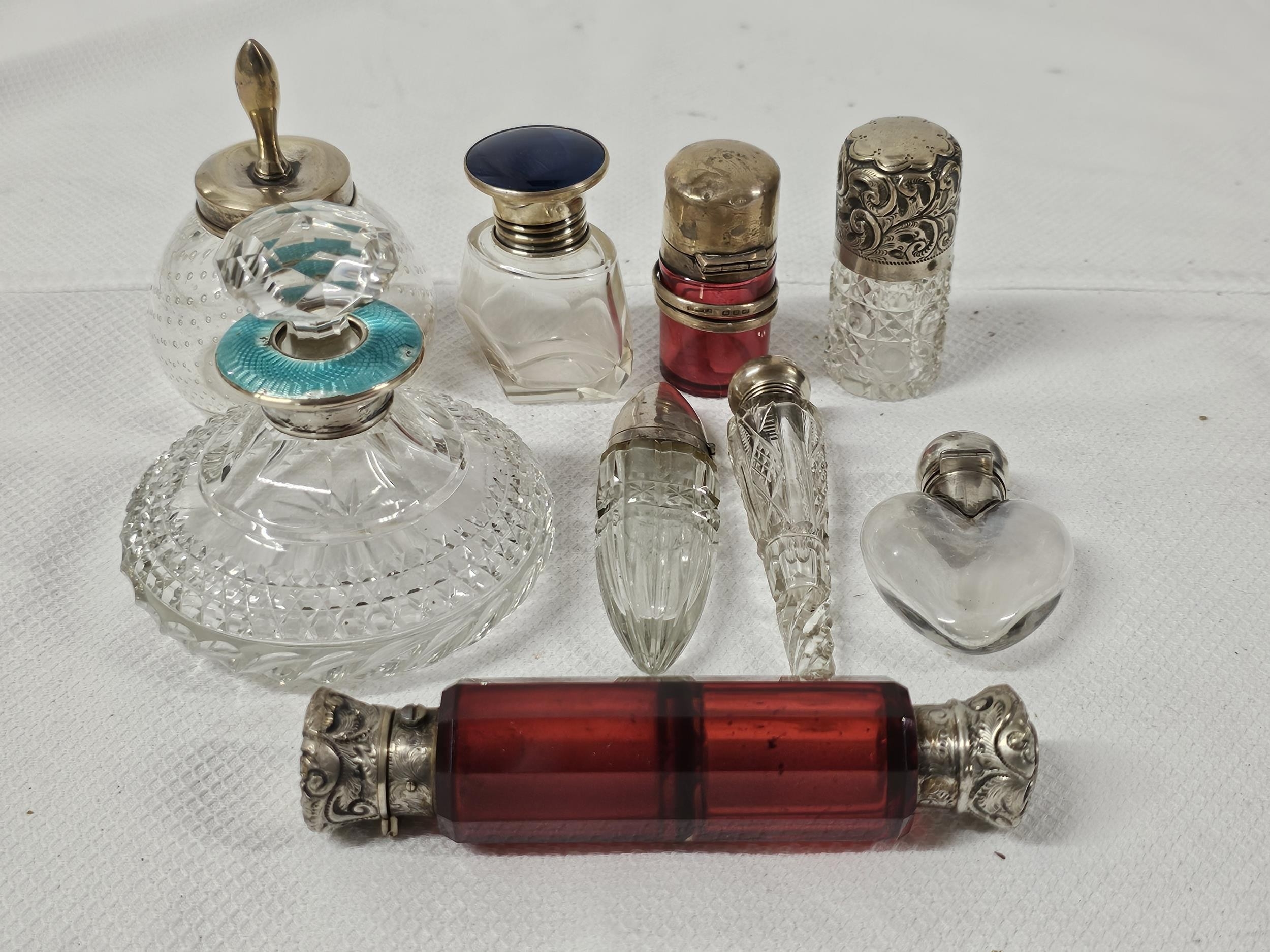 A collection of nine 19th century and early 20th century silver and white metal topped and perfume