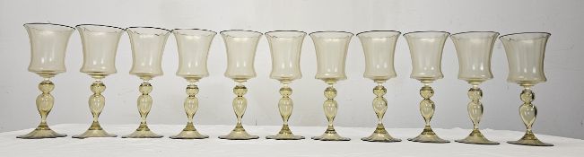 A set of eleven Venetian amber hand blown glass wine glasses with black rims. H.20cm.