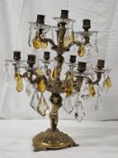 An early 20th century putti form gilt brass candelabra with amber and crystal drops. H.50 W.40 D.