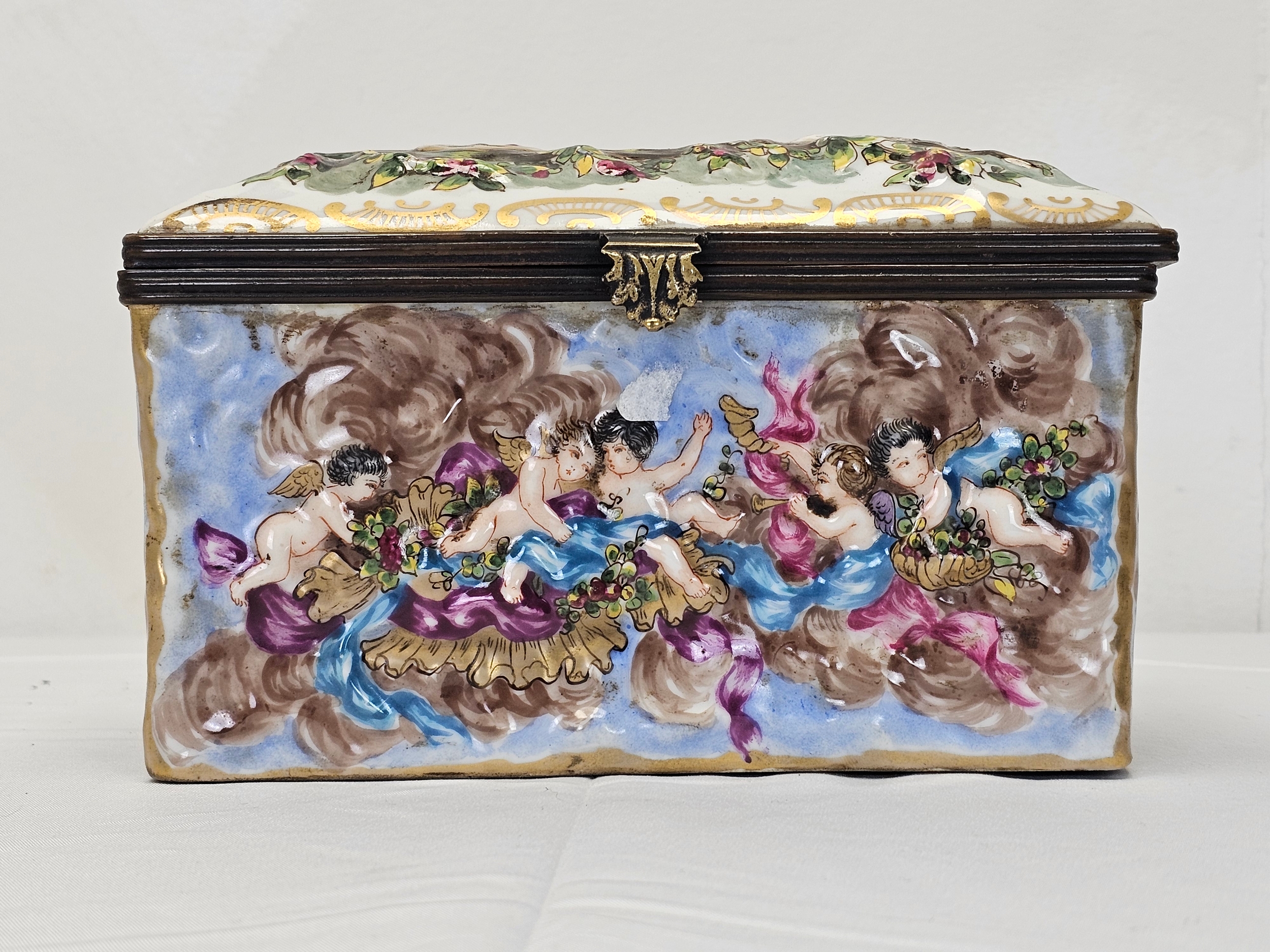 A 20th century Naples Capodimonte rectangular hand painted ceramic lidded box, moulded in low relief