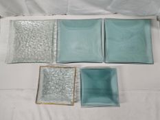 A collection of twenty four square art glass serving plates and side plates, some with gilded edges.
