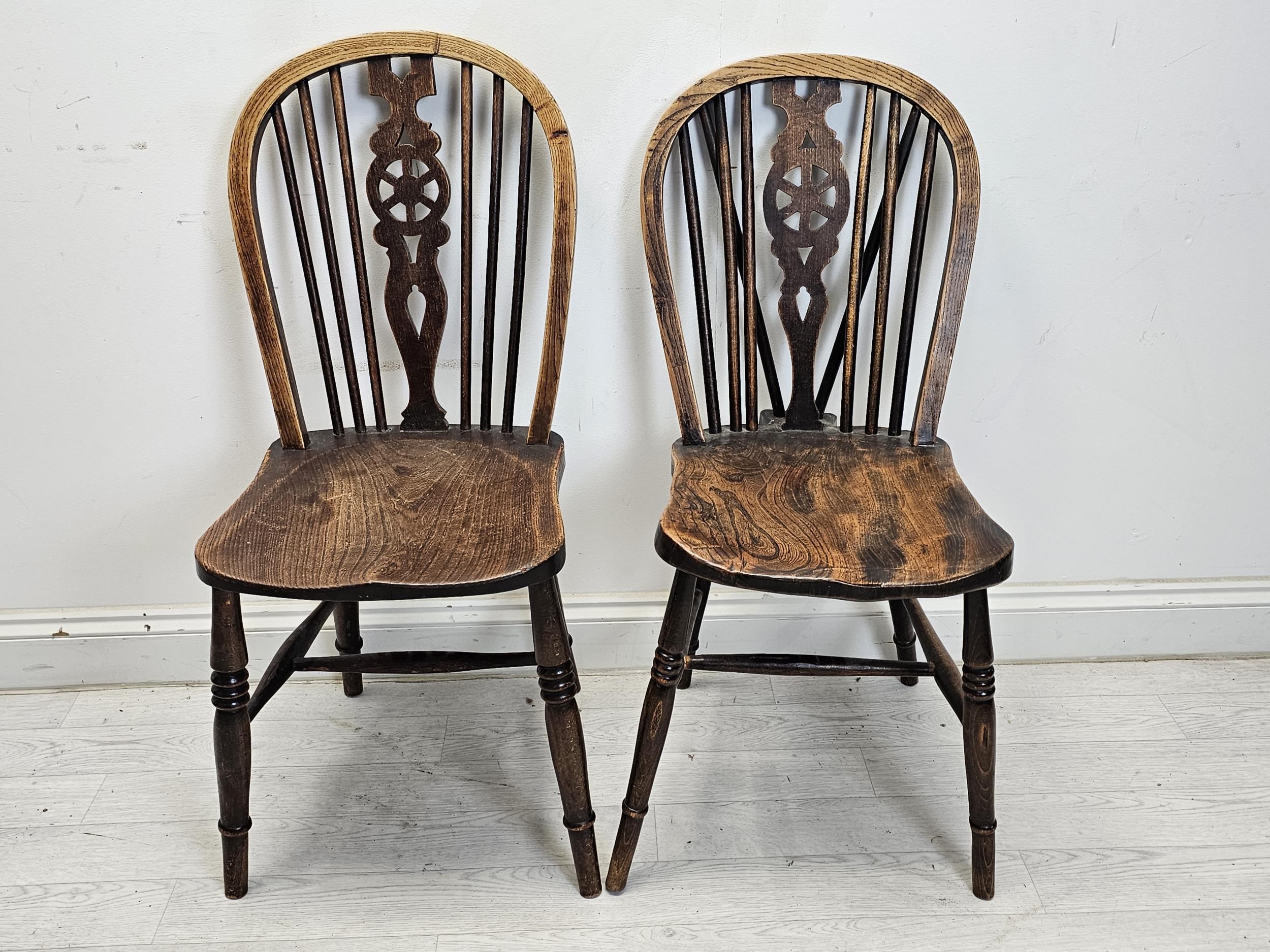 A set of six 19th century Windsor wheelback chairs to include two carver armchairs. (One chair is - Image 6 of 6