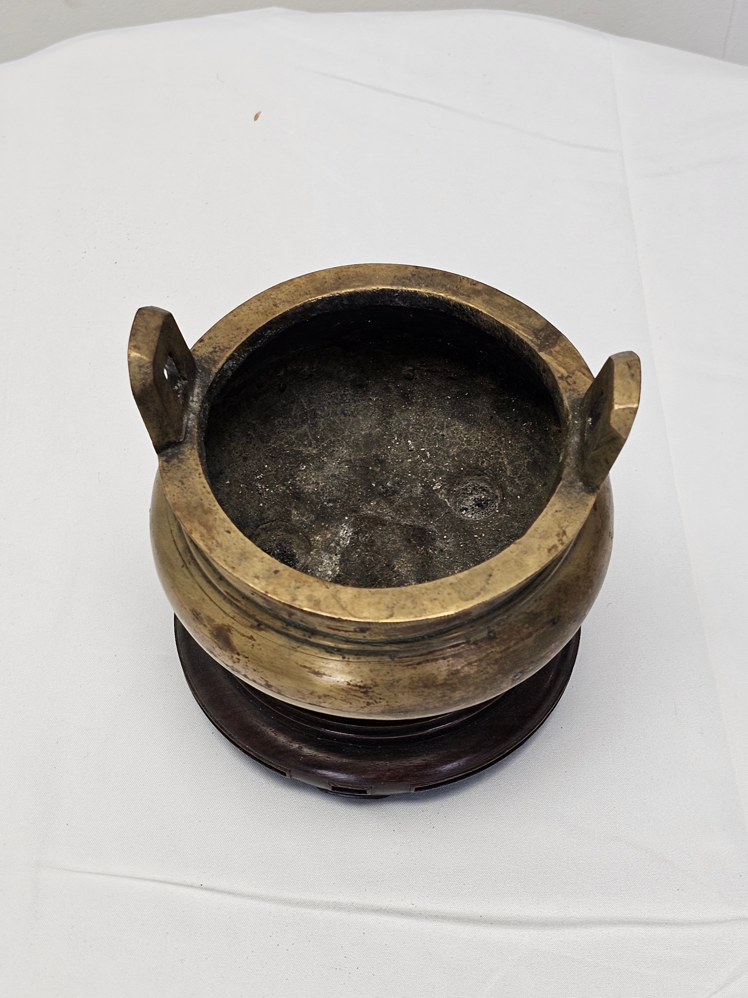 A Chinese twin handled bronze censer with tripod legs on a carved hardwood stand, Xuande marks to - Image 2 of 6