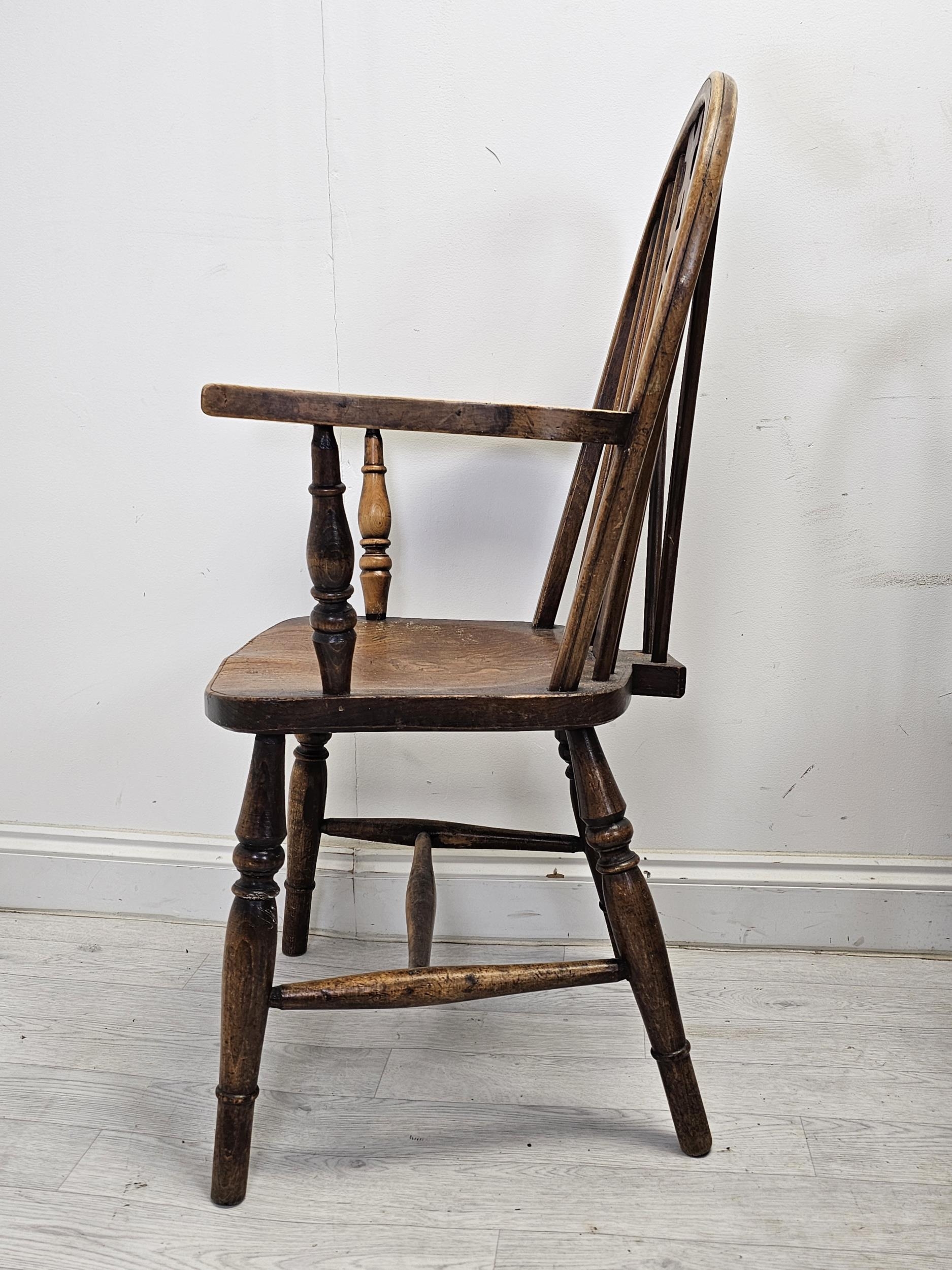 A set of six 19th century Windsor wheelback chairs to include two carver armchairs. (One chair is - Image 4 of 6