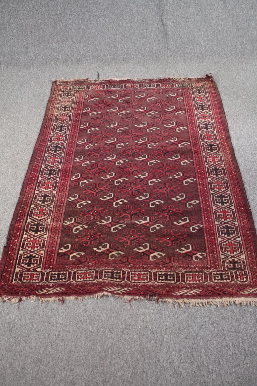 Rug, Belouch with repeating stylised motifs on a burgundy ground within multiple borders. L.167 W.
