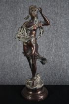 A spelter figure of a flower girl in flowing dress mounted on a turned base. H.43cm.