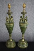 A pair of painted wooden urn design lamps. Decorated with cherubs and a worn greenish gold finish.