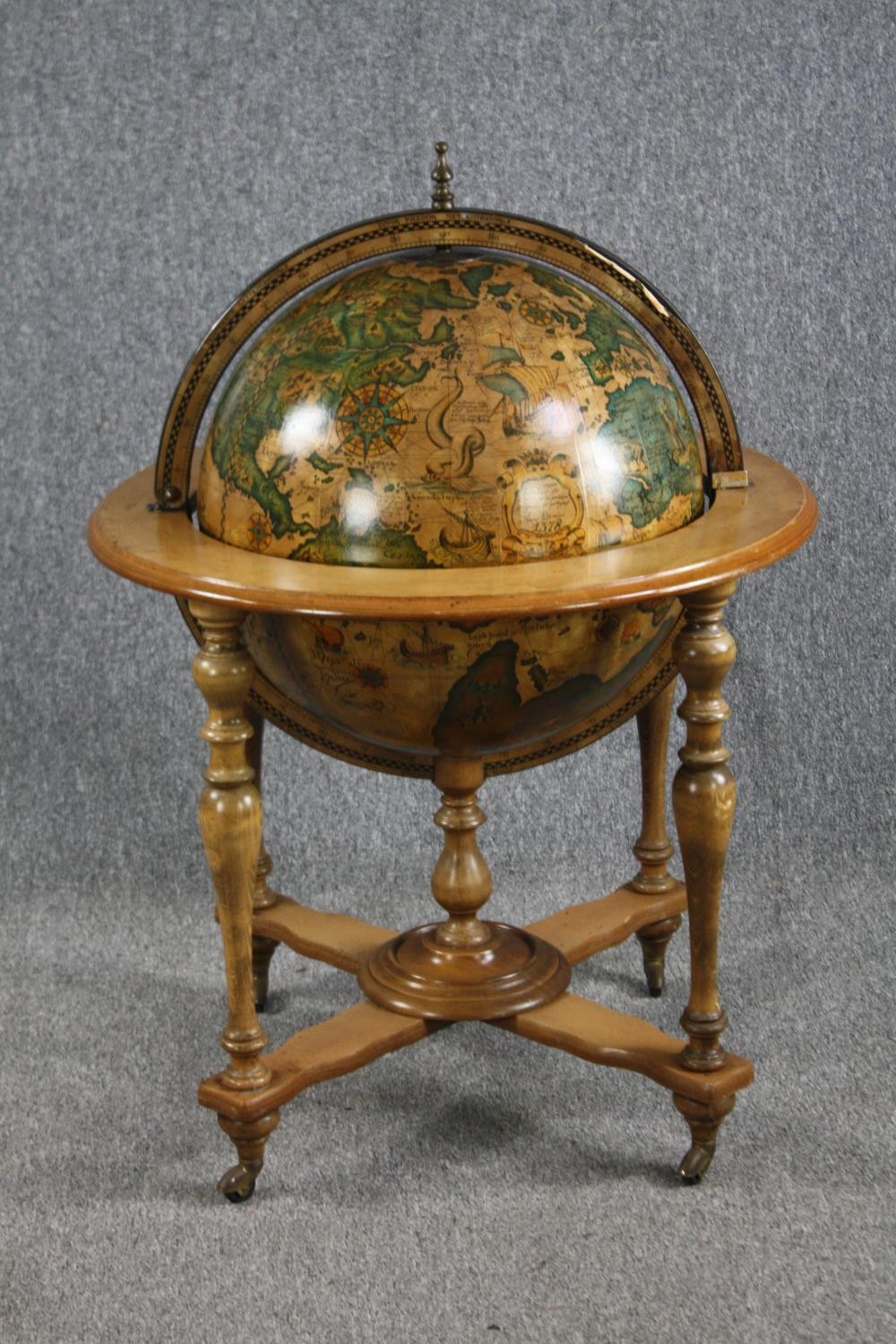 A drinks cabinet in the form of a globe with a fitted interior on a turned beech stand. H.100 Dia.