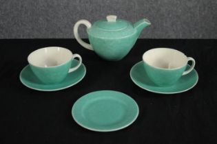 A Poole tea pot with two cups and saucers and a single plate. H.10 W.20cm. (largest)