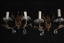 A near pair of early 20th century gilt metal and cut crystal twin branch wall sconces. H.25cm. (