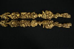 A pair of carved giltwood wall pieces with fruit and foliage design, two silk tassel motifs to the