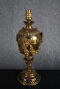 A classical urn design brass table lamp with foliate swags and green man mask motifs. H.39cm.