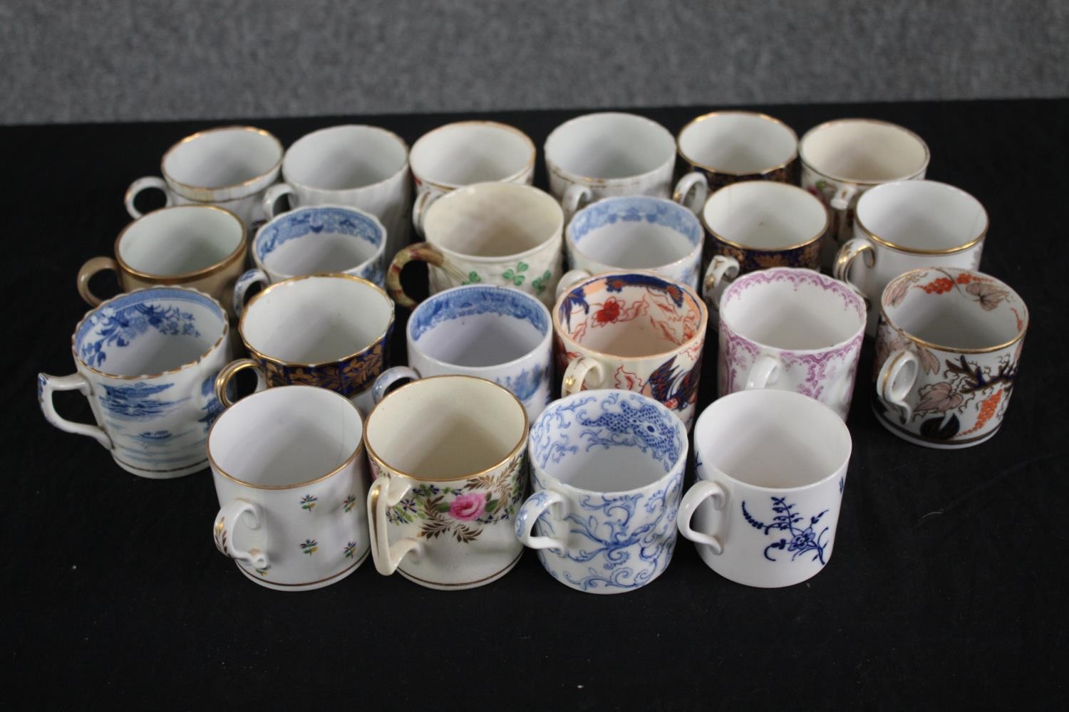 An assortment of 19th century porcelain coffee cans with hand painted design, including one made