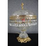 A gilt metal and cut crystal dome table lamp with crystal drop detailing and cherub finial. H.44