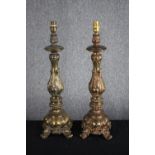A pair of large casts brass lamps with four legged pedestals and raised Rococo revival style