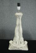 A ceramic lamp supported by two nudes. H.48cm.
