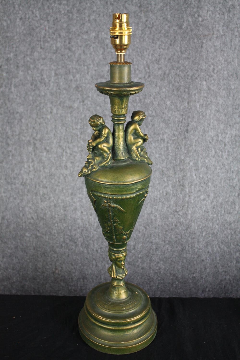 A pair of painted wooden urn design lamps. Decorated with cherubs and a worn greenish gold finish. - Image 2 of 4