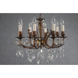 A French foliate design chandelier with seven branches. Brass decorated with hanging tear drop glass