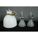 Three modern ceiling lights. A pair of grey lights with an industrial look the other larger and
