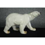 A large stoneware Polar bear. Hand painted and glazed garden ornament. H.26 W.40cm.