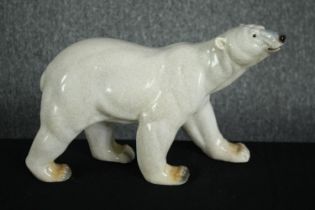 A large stoneware Polar bear. Hand painted and glazed garden ornament. H.26 W.40cm.