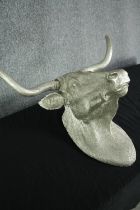 A fibreglass horned bulls head finished in silver. H.54 W.73cm.