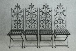 A set of four vintage wrought iron folding chairs. (One missing a part of it's cresting).