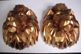 A pair of lion heads. Resin and finished in gold. H.35 W.30 cm.(each)