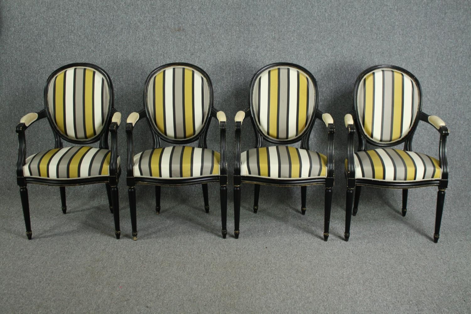 A set of four contemporary Louis XVI style armchairs with ebonised frames in striped upholstery. H.