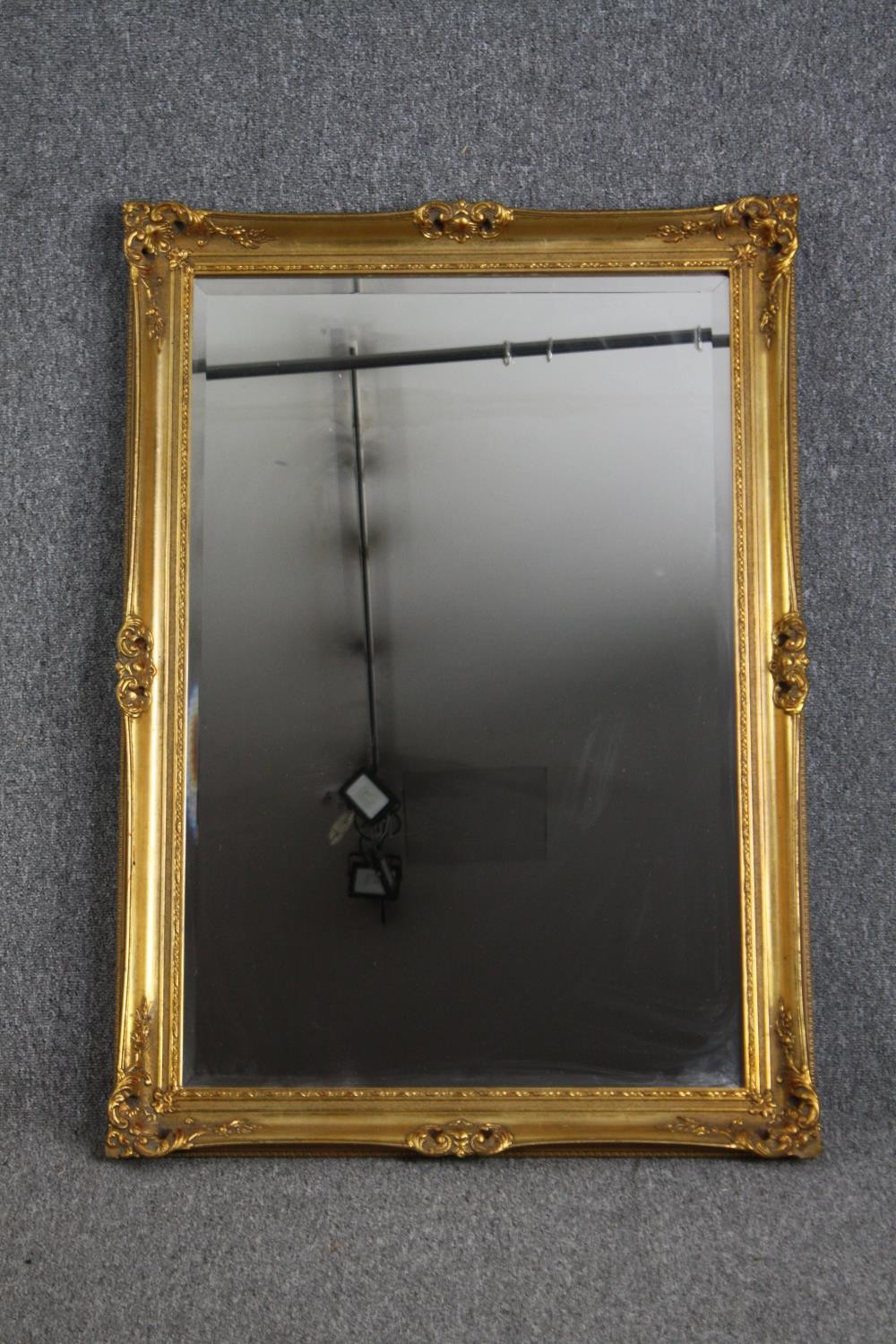 A gilt framed mirror with bevelled plate. H.106 W.75cm.