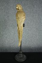 A decorative parrot on a perch. Metal and finished in gold and black. H.78cm.
