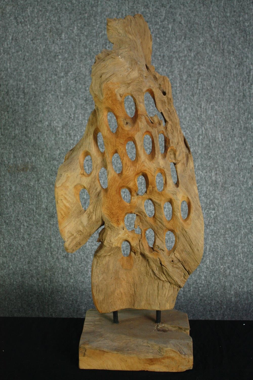 A driftwood abstract sculpture. Honeycombed on a hardwood stand. H.80cm.