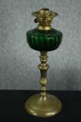 A Victorian oil lamp with a glass tank. Missing its class cover. H.50cm.