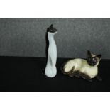 A ceramic and glass cat. The ceramic cat made by Beswick Pottery. The black-and-white glass cat with