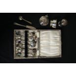 A mixed collection of silver plate including a set of scalloped spoons, a sugar pot, and salt