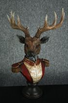 A horned stag bust in Napoleonic uniform. Poly-resin and hand painted. H.42cm.H.48cm.