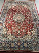 Carpet, Persian with central floral medallion and scrolling foliate motifs on a burgundy ground
