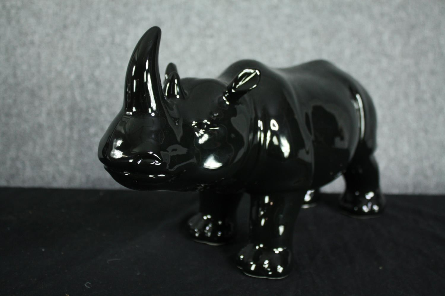 A pair of ceramic rhino figures. In a black painted glaze. H.23 W.40cm. (each) - Image 3 of 3