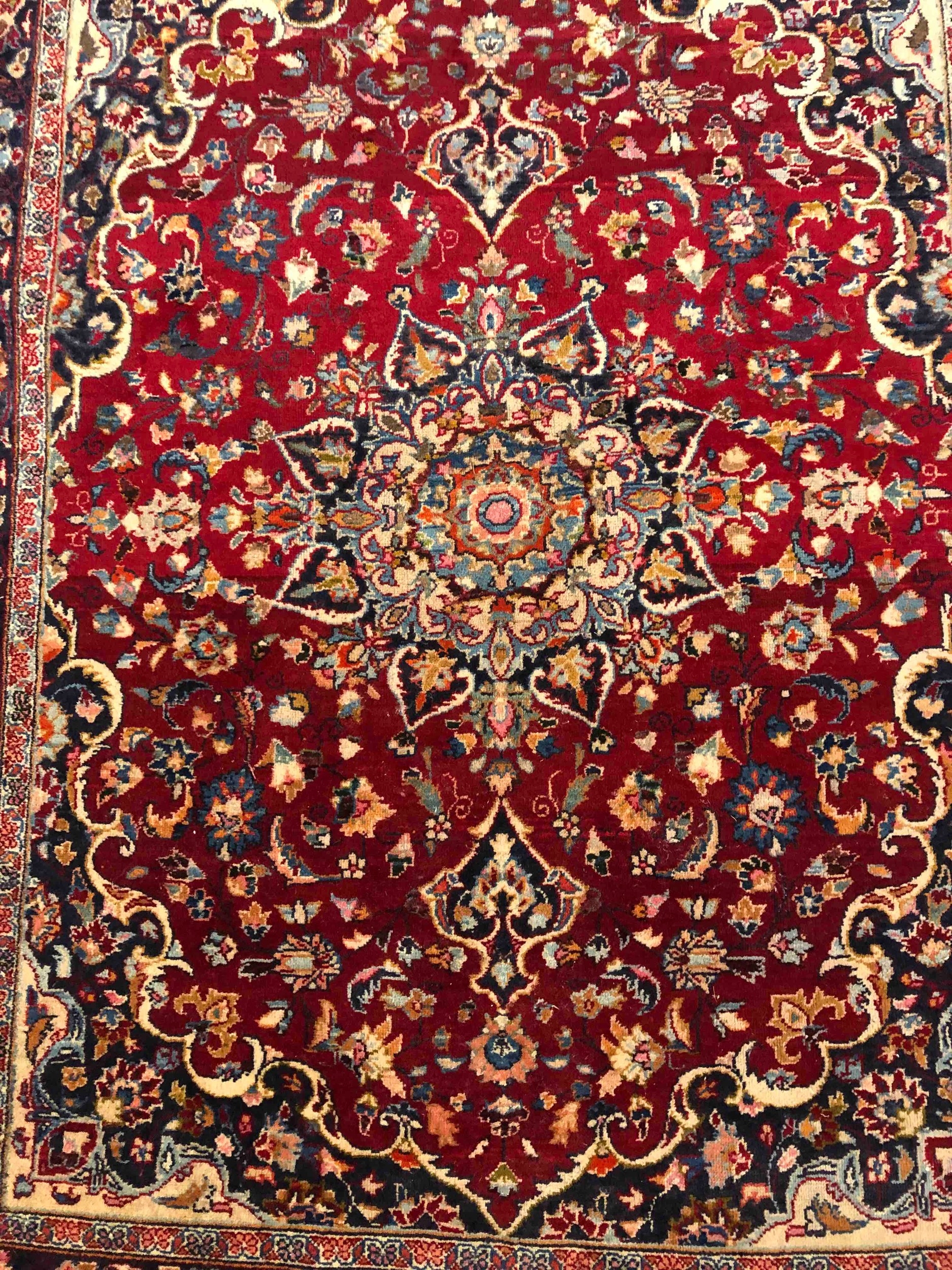 A Persian carpet with flowerhead motifs across the field within naturalistic foliate borders. L. - Image 2 of 3