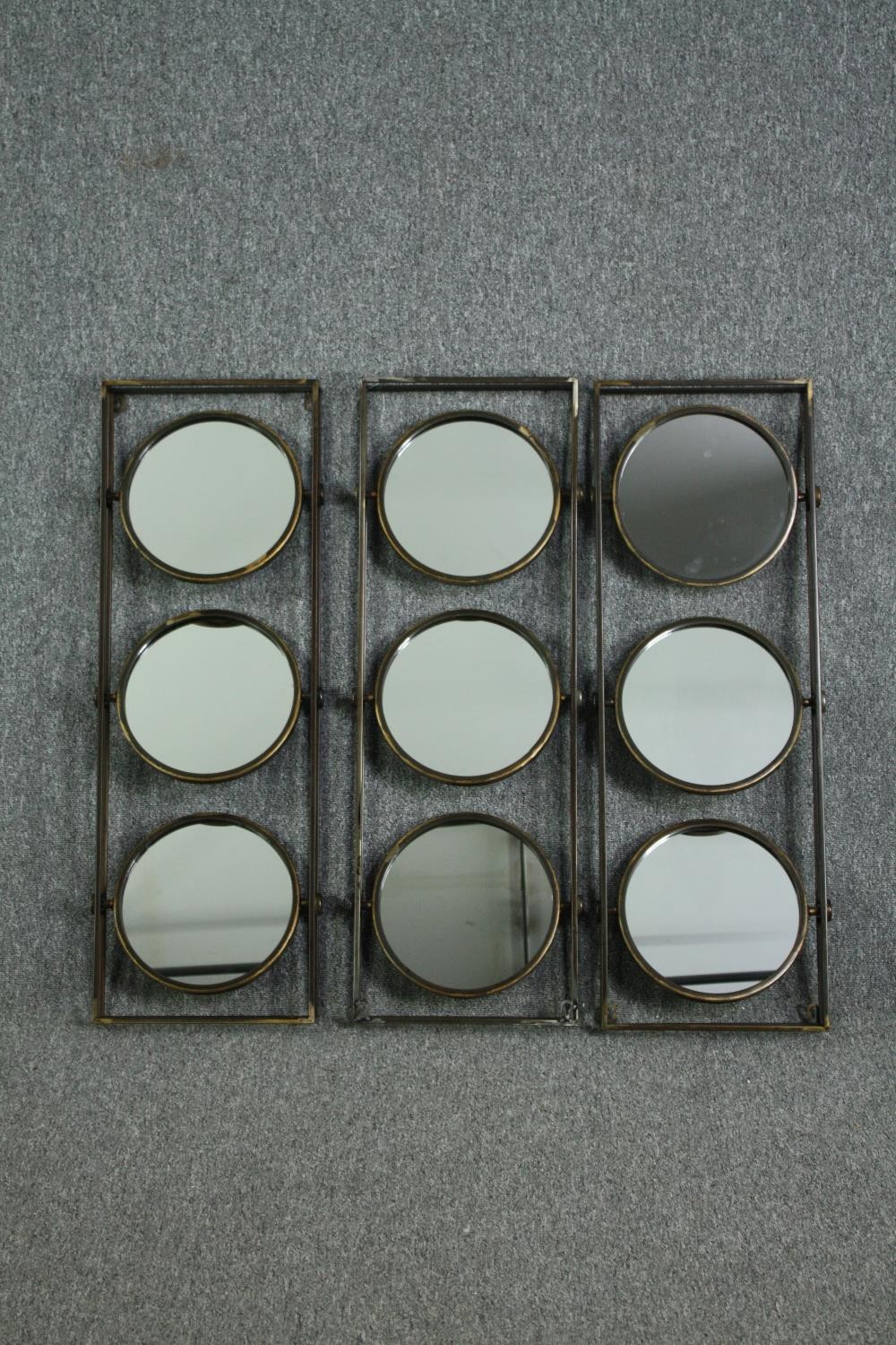 A set of three metal frames each fitted with three swing mirrors. H.90 W.31cm. (each)