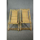 A pair of slatted bamboo deck chairs.