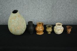A mixed collection of glazed ceramic pots, vases and a small terracotta urn. Studio pottery. Without