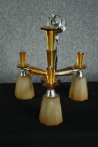 A 1930s Art Deco chandelier. Chromed metal with orange glass surrounds and three branches of