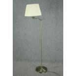 A modern standing floor lamp with articulated adjustable arm. Metal with a brass effect finish. H.