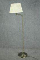A modern standing floor lamp with articulated adjustable arm. Metal with a brass effect finish. H.